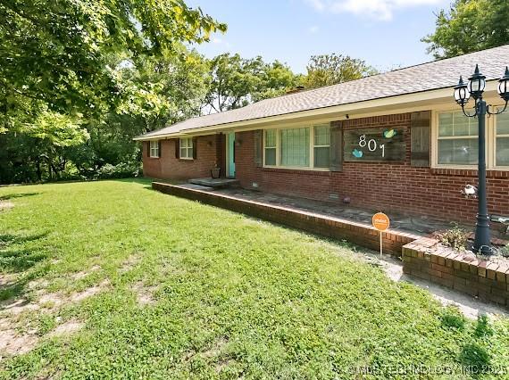 801 S Rennie St, Ada, OK 74820 - view of front of house with a front yard and brick siding