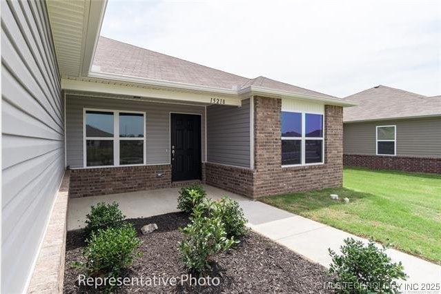 23050 S Mae Dr, Claremore, OK 74019 - view of exterior entry featuring brick siding and a yard
