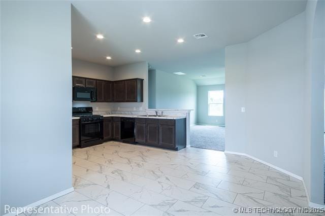 23050 S Mae Dr, Claremore, OK 74019 - kitchen with black appliances, baseboards, light countertops, light marble finish flooring, and dark brown cabinets