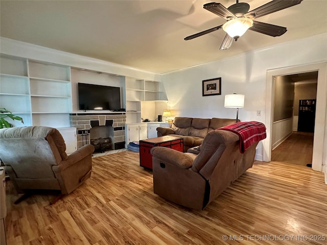 1327 E 10th St, Okmulgee, OK 74447 - living room featuring wood finished floors, a fireplace, ornamental molding, built in features, and a ceiling fan