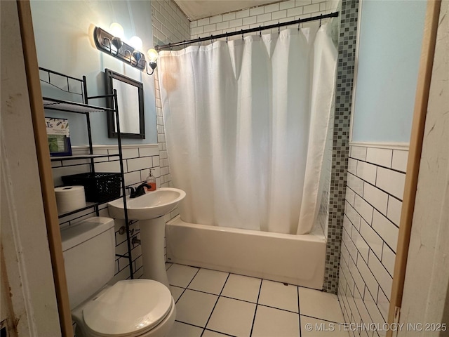 1327 E 10th St, Okmulgee, OK 74447 - full bathroom with tile walls, shower / tub combo with curtain, tile patterned floors, and a wainscoted wall