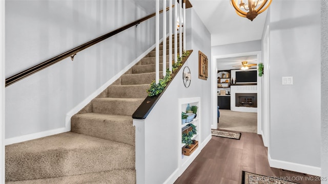 6063 Wilson, Durant, OK 74701 - staircase with a ceiling fan, baseboards, wood finished floors, a fireplace, and built in features