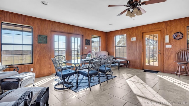 6063 Wilson, Durant, OK 74701 - dining room featuring plenty of natural light, wooden walls, a ceiling fan, baseboards, and light tile patterned flooring