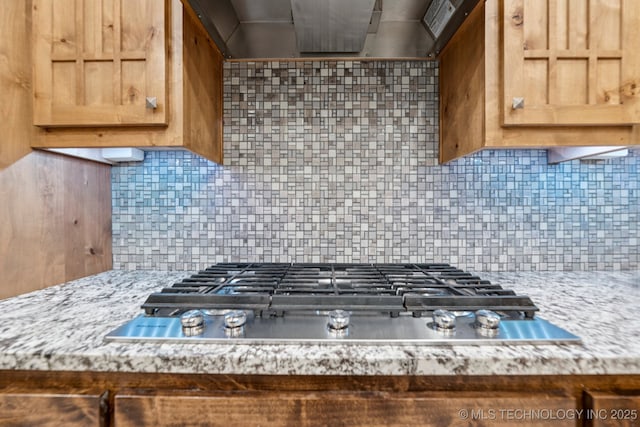 15303 Foreacre Cir, Sapulpa, OK 74066 - kitchen with stainless steel gas cooktop, island exhaust hood, tasteful backsplash, and light stone countertops