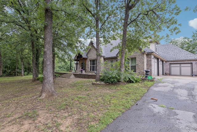 15303 Foreacre Cir, Sapulpa, OK 74066 - view of front of property with a garage, asphalt driveway, a shingled roof, and brick siding