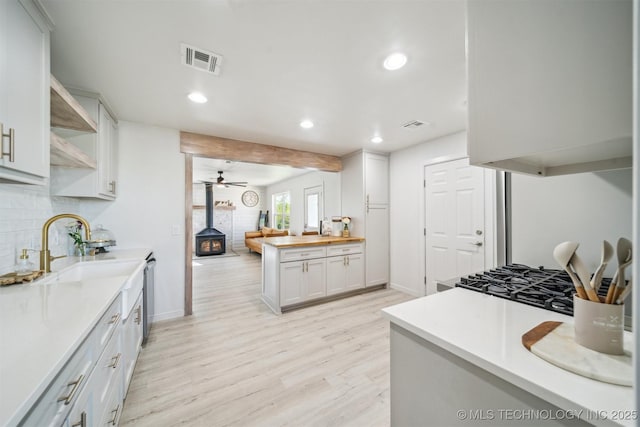 11860 N 68th W Ave, Sperry, OK 74073 - kitchen featuring a wood stove, recessed lighting, light wood-style flooring, open shelves, and tasteful backsplash