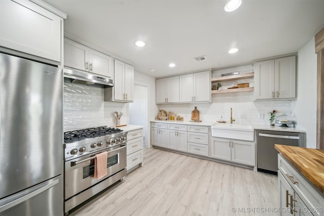 11860 N 68th W Ave, Sperry, OK 74073 - kitchen featuring appliances with stainless steel finishes, under cabinet range hood, a sink, wooden counters, and backsplash