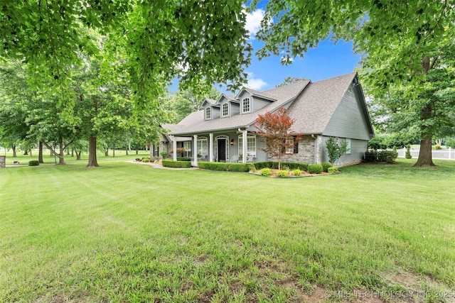 5070 Lake Breeze Rd, Grove, OK 74344 - cape cod-style house with a porch, a front yard, roof with shingles, and stone siding
