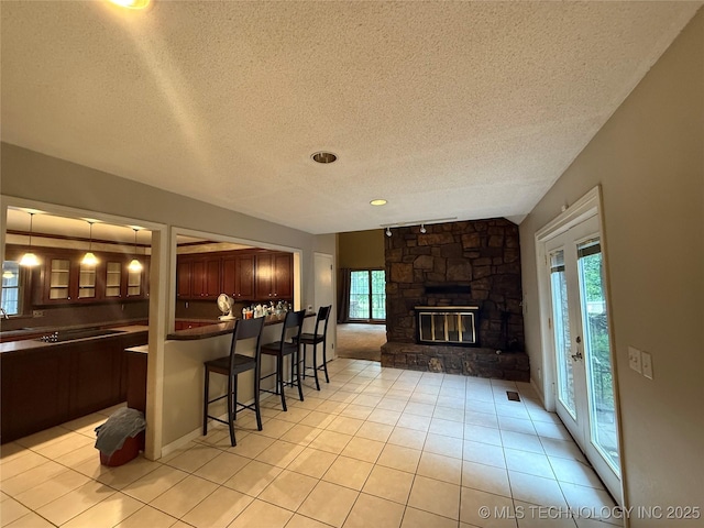 1808 N Woodland, Drumright, OK 74030 - living area featuring light tile patterned flooring, a textured ceiling, plenty of natural light, and a fireplace