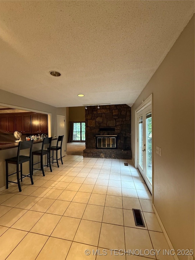 1808 N Woodland, Drumright, OK 74030 - living room featuring a textured ceiling, light tile patterned flooring, and a fireplace