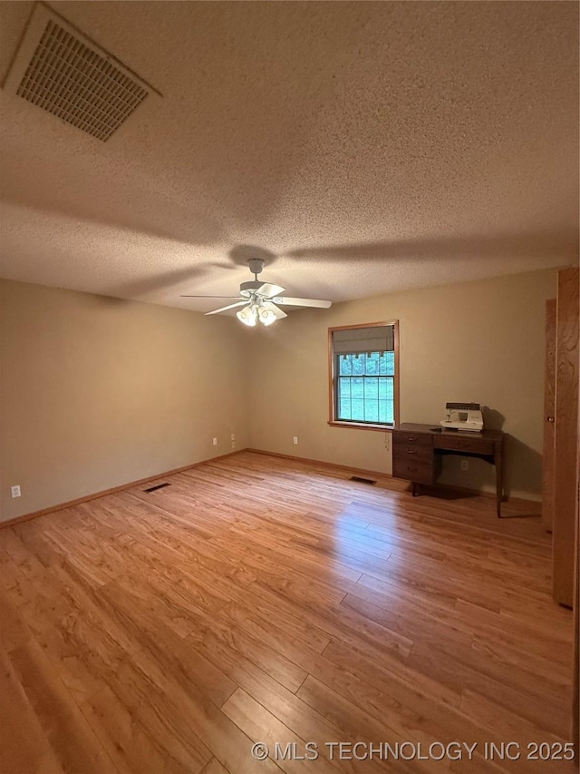 1808 N Woodland, Drumright, OK 74030 - spare room featuring a textured ceiling, light wood-style floors, and a ceiling fan