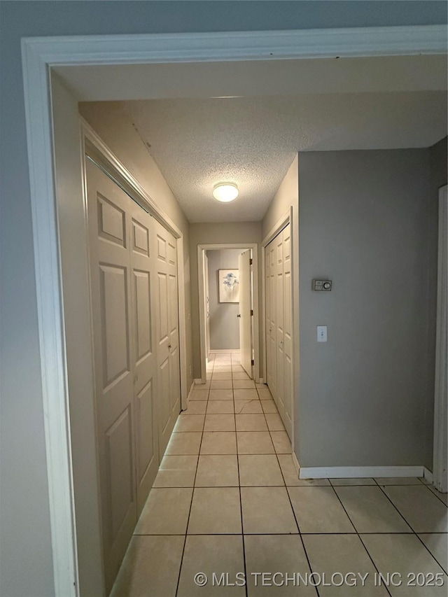 1808 N Woodland, Drumright, OK 74030 - hall with light tile patterned flooring, baseboards, and a textured ceiling