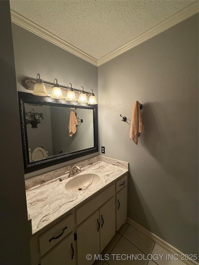 1808 N Woodland, Drumright, OK 74030 - bathroom featuring a textured ceiling, ornamental molding, vanity, tile patterned flooring, and baseboards