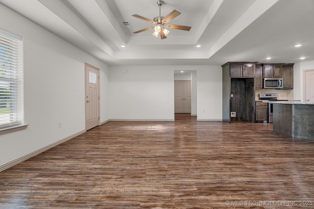 3923 Bryan Rd, Durant, OK 74701 - unfurnished living room with dark wood-style flooring, a tray ceiling, ceiling fan, recessed lighting, and baseboards