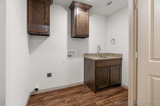 3923 Bryan Rd, Durant, OK 74701 - laundry area featuring hookup for a washing machine, electric dryer hookup, dark wood-style floors, baseboards, and cabinet space