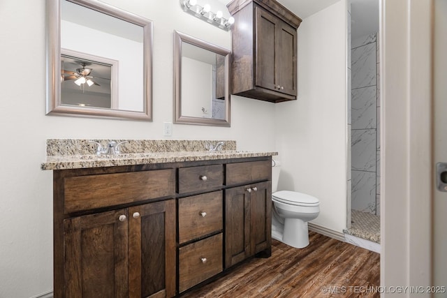 3923 Bryan Rd, Durant, OK 74701 - bathroom with double vanity, toilet, a shower stall, wood finished floors, and a ceiling fan