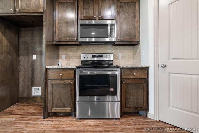 3923 Bryan Rd, Durant, OK 74701 - kitchen with appliances with stainless steel finishes, dark brown cabinetry, and backsplash