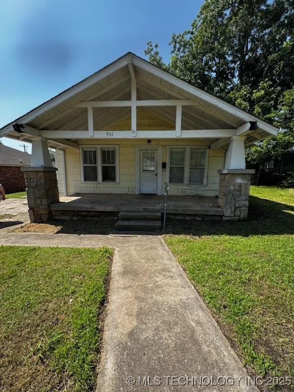 911 E 3rd St, Cushing, OK 74023 - bungalow featuring a porch and a front yard