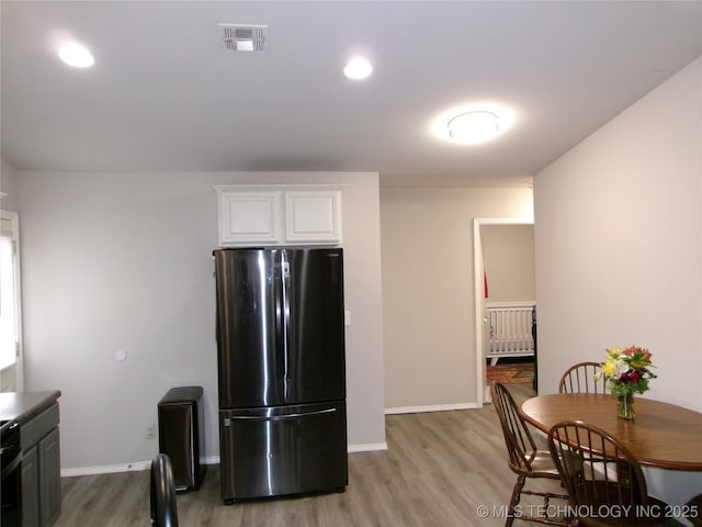 7882 E 132nd Pl S, Bixby, OK 74008 - kitchen featuring freestanding refrigerator, light wood-style flooring, white cabinetry, baseboards, and radiator heating unit