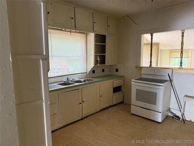 201 E Main St, Henryetta, OK 74437 - kitchen featuring white electric stove, a sink, a textured ceiling, light countertops, and light flooring