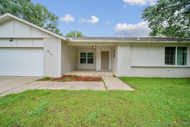 816 W Birmingham St, Broken Arrow, OK 74011 - view of front facade with brick siding, driveway, a front lawn, and a garage
