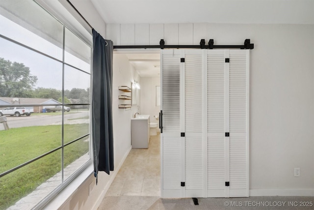 816 W Birmingham St, Broken Arrow, OK 74011 - hall with a barn door, plenty of natural light, and baseboards