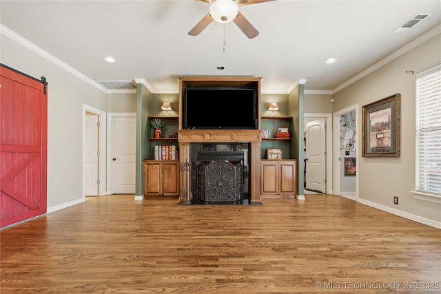 18578 S 269th E Ave, Haskell, OK 74436 - living area featuring light wood finished floors, ceiling fan, a barn door, crown molding, and baseboards