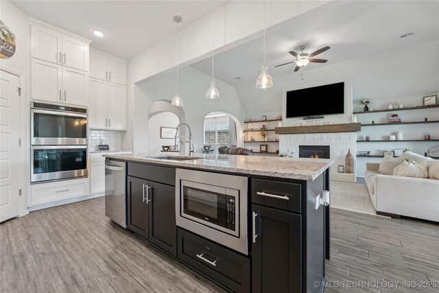 7000 S Elder Ave, Broken Arrow, OK 74011 - kitchen with appliances with stainless steel finishes, a sink, white cabinetry, open floor plan, and ceiling fan