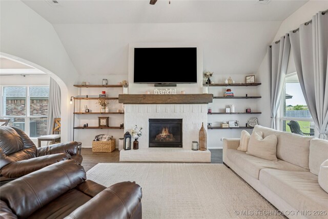7000 S Elder Ave, Broken Arrow, OK 74011 - living area featuring vaulted ceiling, wood finished floors, arched walkways, a brick fireplace, and ceiling fan
