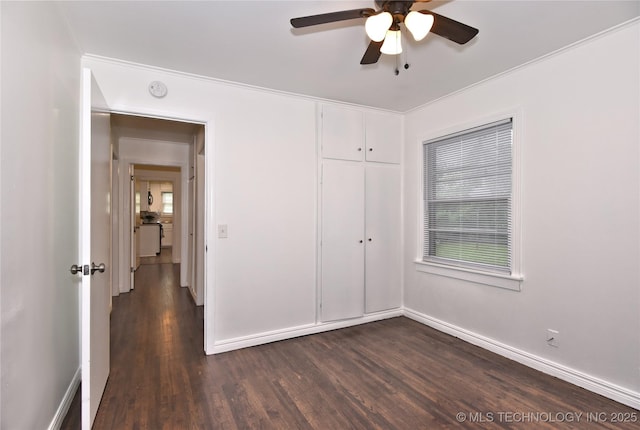 1373 E 42nd Pl N, Tulsa, OK 74105 - unfurnished bedroom featuring dark wood-style floors, baseboards, a closet, and ceiling fan