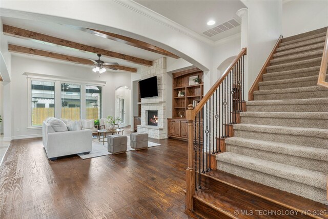 5314 E 125th St S, Bixby, OK 74008 - living room with ceiling fan, stairway, dark wood-style floors, arched walkways, and a fireplace