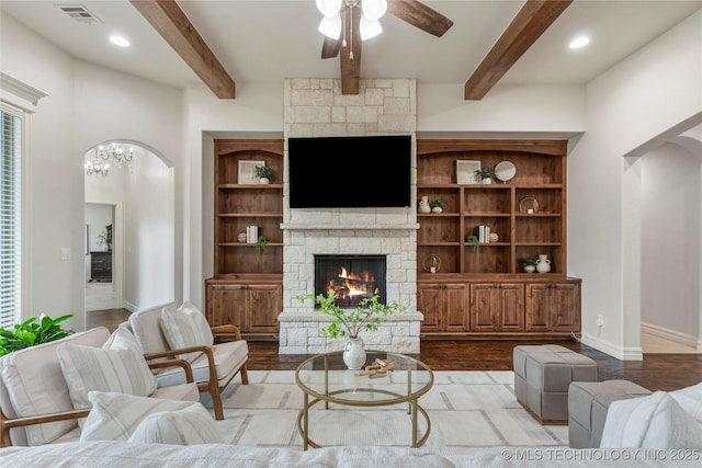 5314 E 125th St S, Bixby, OK 74008 - living room with a stone fireplace, arched walkways, a ceiling fan, beam ceiling, and wood finished floors