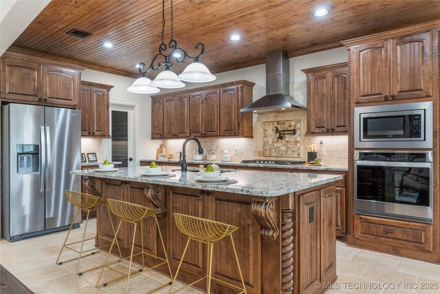 5314 E 125th St S, Bixby, OK 74008 - kitchen featuring appliances with stainless steel finishes, wall chimney range hood, light stone counters, backsplash, and an island with sink
