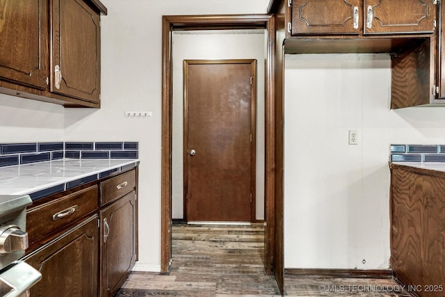 32112 E 721st Rd, Wagoner, OK 74467 - kitchen featuring wood finished floors, light countertops, dark brown cabinetry, and decorative backsplash