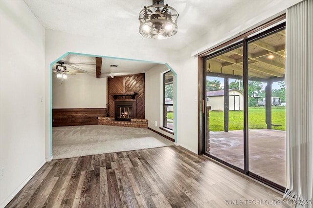 32112 E 721st Rd, Wagoner, OK 74467 - unfurnished living room with wood finished floors, a fireplace, ceiling fan, and baseboards