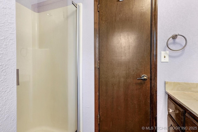 32112 E 721st Rd, Wagoner, OK 74467 - bathroom with a stall shower, vanity, and a textured wall