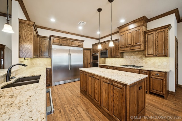 21 E 171st St S, Glenpool, OK 74033 - kitchen with built in appliances, a sink, ornamental molding, a kitchen island, and wood finished floors