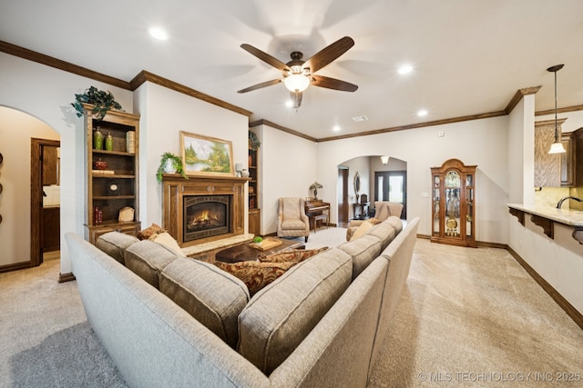21 E 171st St S, Glenpool, OK 74033 - living area featuring arched walkways, ceiling fan, light colored carpet, recessed lighting, and a glass covered fireplace