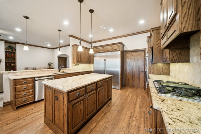 21 E 171st St S, Glenpool, OK 74033 - kitchen with appliances with stainless steel finishes, light wood-style flooring, a peninsula, crown molding, and a kitchen island