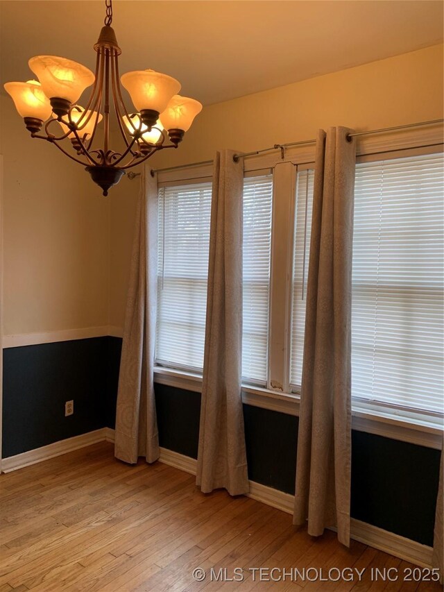 141 N College Ave, Tulsa, OK 74110 - unfurnished room featuring light wood-type flooring and a chandelier