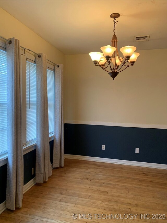 141 N College Ave, Tulsa, OK 74110 - unfurnished room with a chandelier and light wood finished floors