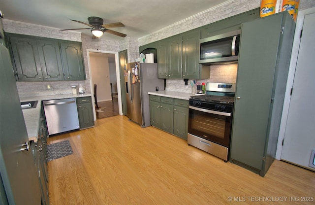 120 S Camden St, Muskogee, OK 74403 - kitchen featuring stainless steel appliances, green cabinetry, light countertops, and tasteful backsplash