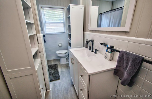 120 S Camden St, Muskogee, OK 74403 - full bathroom featuring tile walls, wood finished floors, vanity, toilet, and a shower with shower curtain