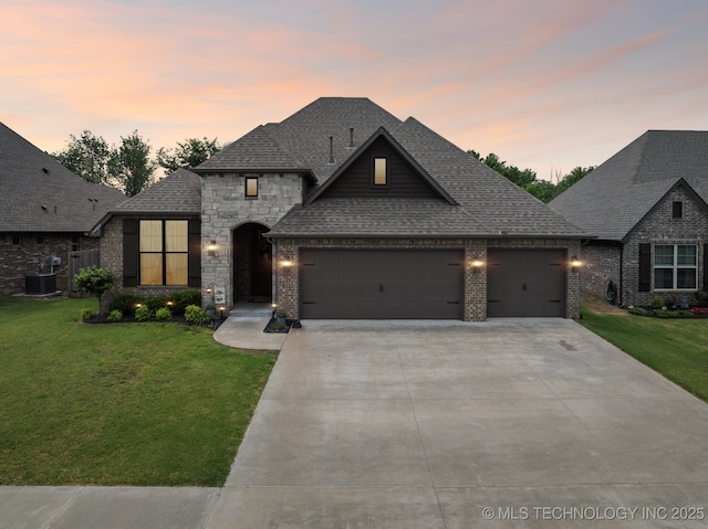7408 E 81st Pl, Owasso, OK 74055 - french country inspired facade featuring an attached garage, a front lawn, concrete driveway, and brick siding