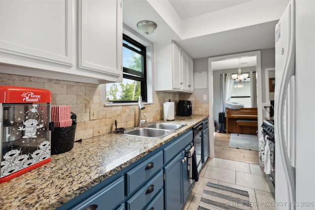 4211 E 101st St N, Sperry, OK 74073 - kitchen with blue cabinets, freestanding refrigerator, a sink, and white cabinets