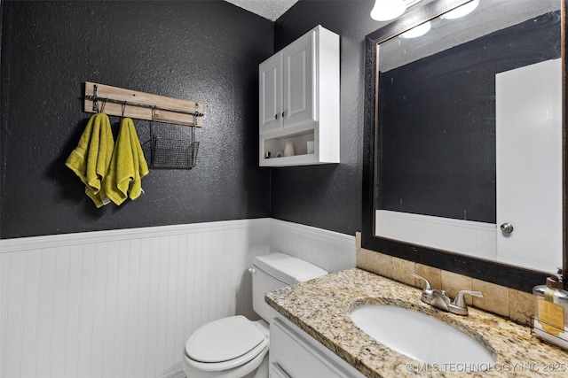 4211 E 101st St N, Sperry, OK 74073 - half bathroom featuring a wainscoted wall, toilet, and vanity