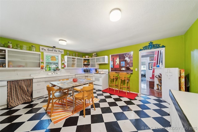 528 S Muskogee, Tahlequah, OK 74464 - kitchen with white gas range, tile patterned floors, light countertops, open shelves, and a textured ceiling