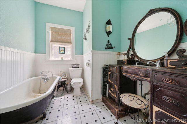 528 S Muskogee, Tahlequah, OK 74464 - bathroom featuring a wainscoted wall, a freestanding bath, vanity, toilet, and tile patterned floors