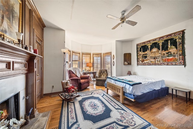 11601 S 193rd E Ave, Broken Arrow, OK 74014 - bedroom with a fireplace with flush hearth, wood finished floors, and a ceiling fan