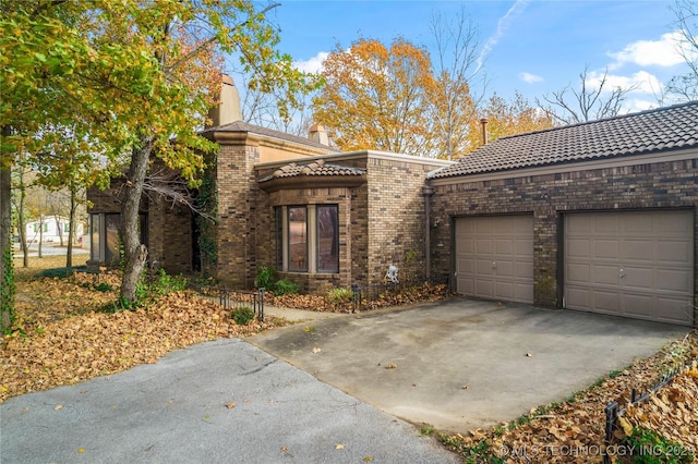 11601 S 193rd E Ave, Broken Arrow, OK 74014 - view of front facade featuring asphalt driveway, a garage, brick siding, and a tiled roof